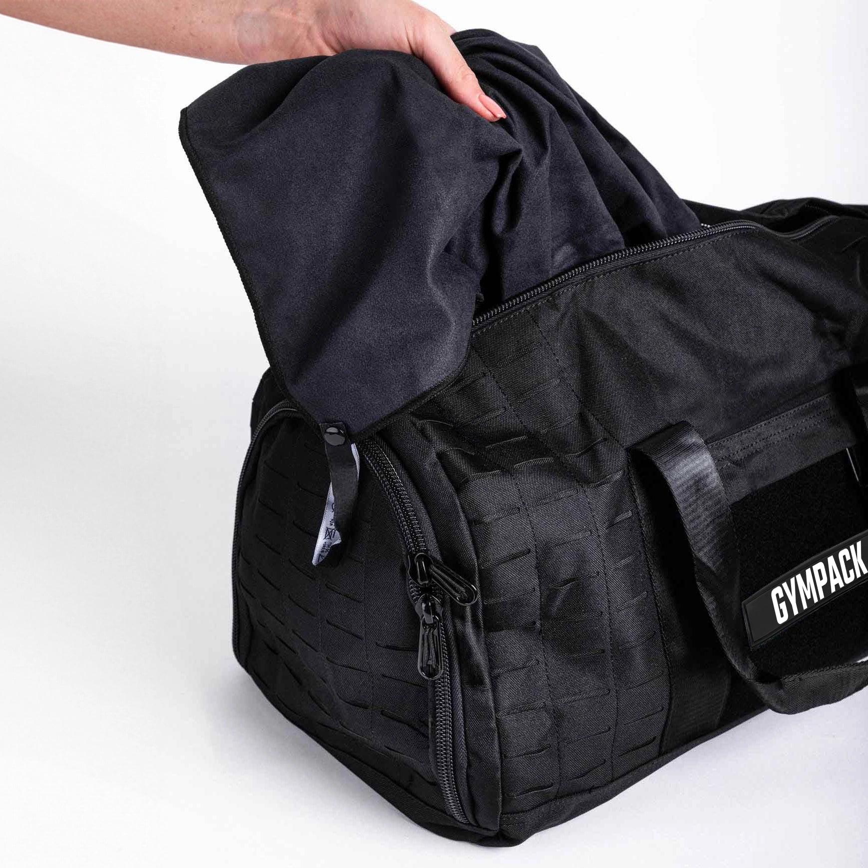 Bolsa Gympack Duffel 40L Preta - Vista Lateral com Modelo Inserindo Item