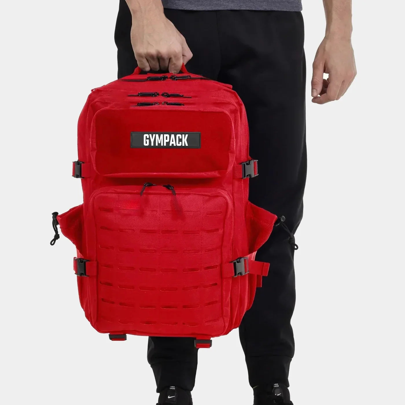 Mochila Gympack Pro 50 Litros Vermelha - Vista Frontal com Modelo Segurando pela Alça Superior